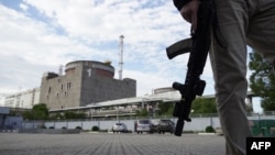 A security person stands in front of the Zaporizhzhia nuclear power plant, amid the ongoing Russian military action in Ukraine, Sept. 11, 2022. 