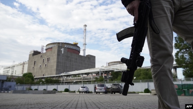 FILE - A security guard stands in front of one of the reactors of the Russia-seized Zaporizhzhia nuclear power plant, amid Russia's ongoing invasion of Ukraine, Sept. 11, 2022.