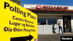 A voter arrives to cast ballots at a local restaurant being used as a polling station in California November 2, 2010. The signboard has translations in Spanish, Tagalog and Vietnamese.