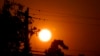 FILE - Sunrise is viewed between power lines in Sacramento, Calif., Sept. 8, 2022. 