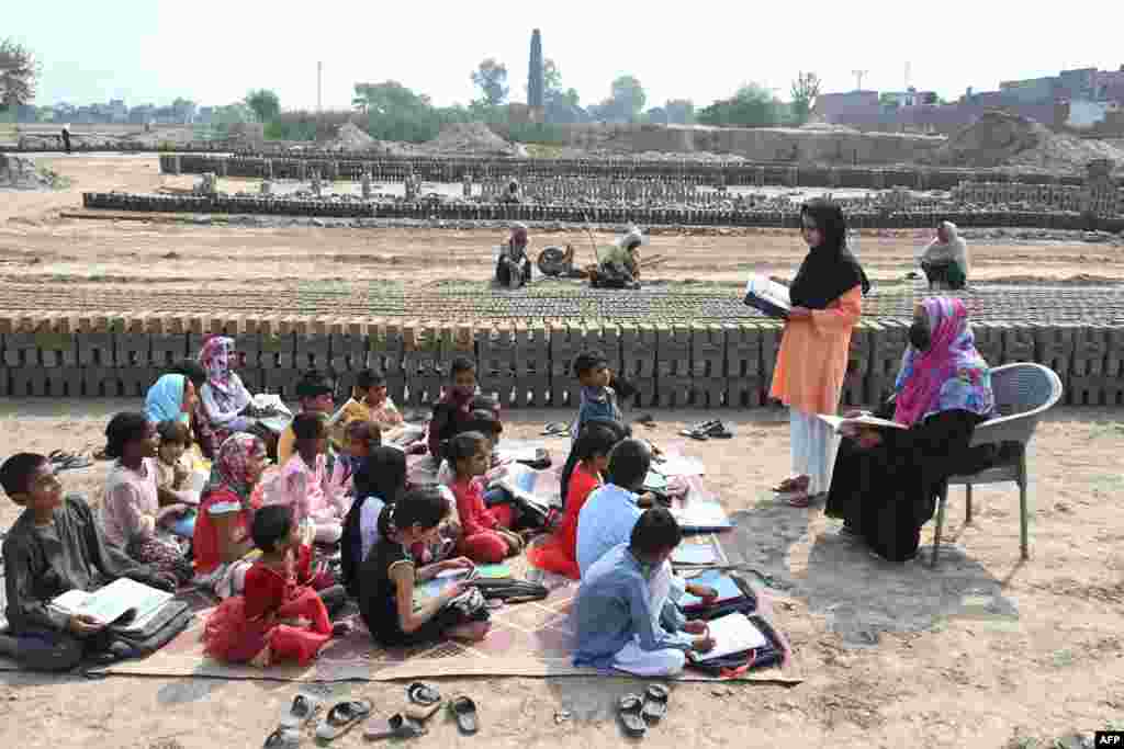 Children of brick kiln workers attend a class at a brick kiln site in Lahore, Pakistan.