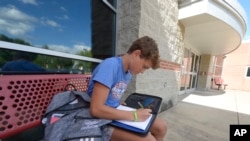 Braylon Price, 13, writes a note before heading home from Bellefonte Middle School Wednesday, Aug. 31, 2022, in Bellefonte, Pa. (AP Photo/Gary M. Baranec)