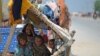 Internally displaced flood-affected children rest under makeshift shelter along a road in higher ground in flooded area after heavy monsoon rains on the outskirts of Jacobabad, Sindh province, Sept. 6, 2022.