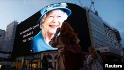 People takes photos of an image of Queen Elizabeth displayed at Piccadilly Circus n London, after she died, Sept. 8, 2022. (Reuters)