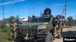 Sejumlah tentara Ukraina berpatroli di Kota Kupiansk, di wilayah Kharkiv, yang baru saja dibebaskan di tengah invasi Rusia ke Ukraina, Jumat, 9 September 2022. (Foto: Biro Pers Dinas Keamanan Negara Ukraina via Reuters)