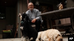 Gordon Haberman sits for a photo with his two dogs, Sept. 6, 2022 in West Bend, Wis.