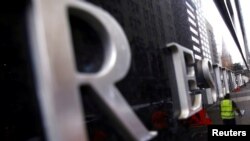 FILE - A worker is reflected in a wall of the Reserve Bank of Australia (RBA) head office in central Sydney, March 1, 2016. 