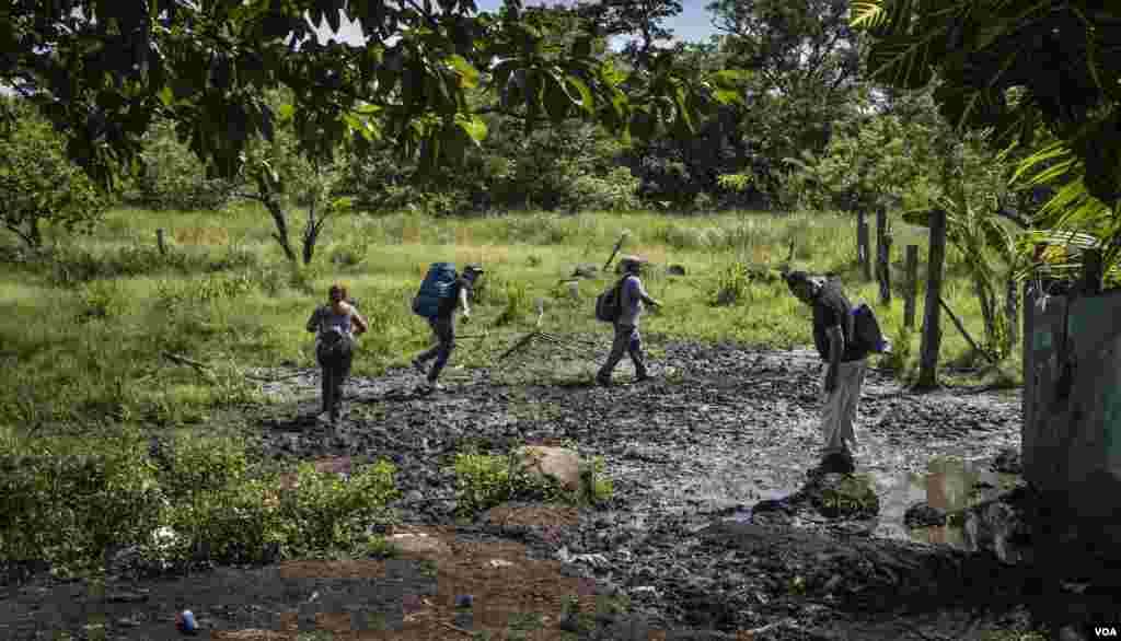 Los migrantes ya en territorio de Costa Rica siguen sobre caminos y trochas llenas de fango. En esta parte de la frontera buscan cómo salir a la estación del autobus. [Oscar Navarrete: La Prensa- VOA]