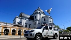 Un vehículo policial pasa frente a la Catedral de Caacupé, a las afueras de Asunción, el 7 de diciembre de 2020.