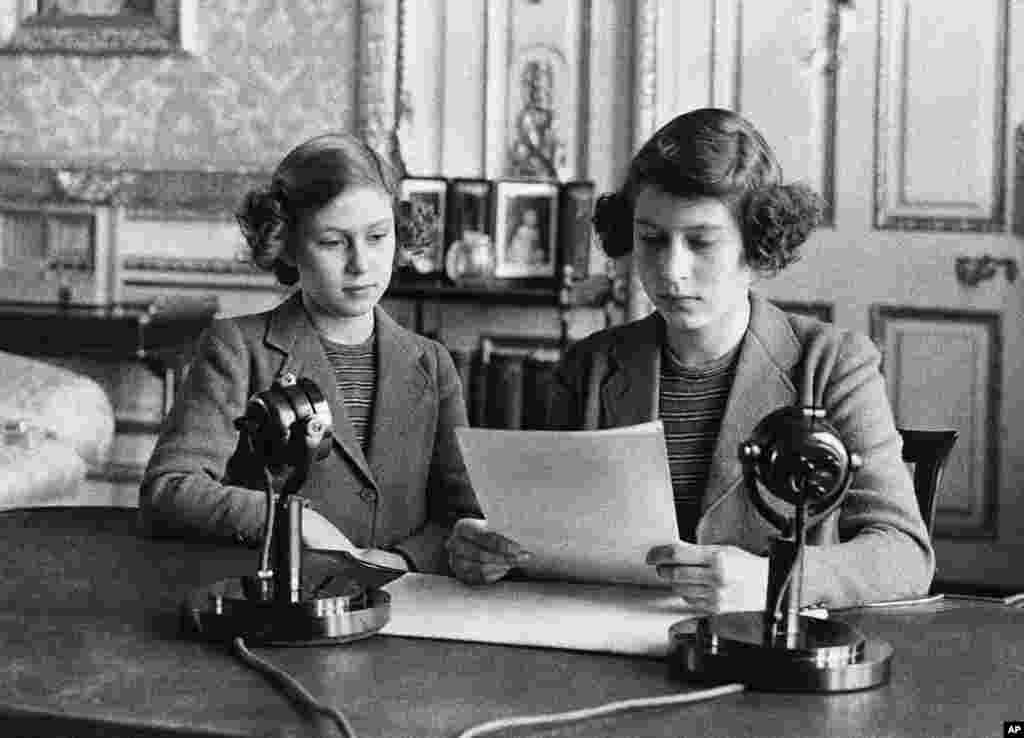 اولین سخنرانی رادیویی شاهدخت الیزابت در ۱۴ سالگی در لندن. خواهرش شاهدخت مارگارت رُز کنار او نشسته است. (۱۳ اکتبر ۱۹۴۰)