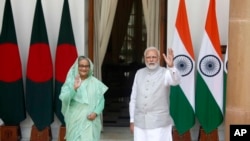 Indian Prime Minister Narendra Modi, right, and his Bangladeshi counterpart Sheikh Hasina wave to the waiting media before their delegation level talks in New Delhi, India, Sept. 6, 2022.
