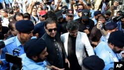 Former Pakistani Prime Minister Imran Khan, center, arrives to the Islamabad High Court surrounded by journalists and security in Islamabad, Pakistan, Sept. 8, 2022.