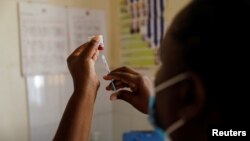 FILE - A nurse fills a syringe with malaria vaccine before administering it to an infant at the Lumumba Sub-County hospital in Kisumu, Kenya, July 1, 2022. 