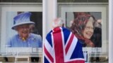 A man looks at framed portraits of Queen Elizabeth II in a shop window near Windsor Castle in Windsor, England.
