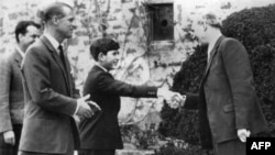 FILE - Britain's Prince Charles greets Robert Chew, the headmaster of Gordonstoun School, on his first day as a pupil, on May 1, 1962 at his arrival in Elgin, Scotland, as his father Philip, Duke of Edinburgh (L) looks on.