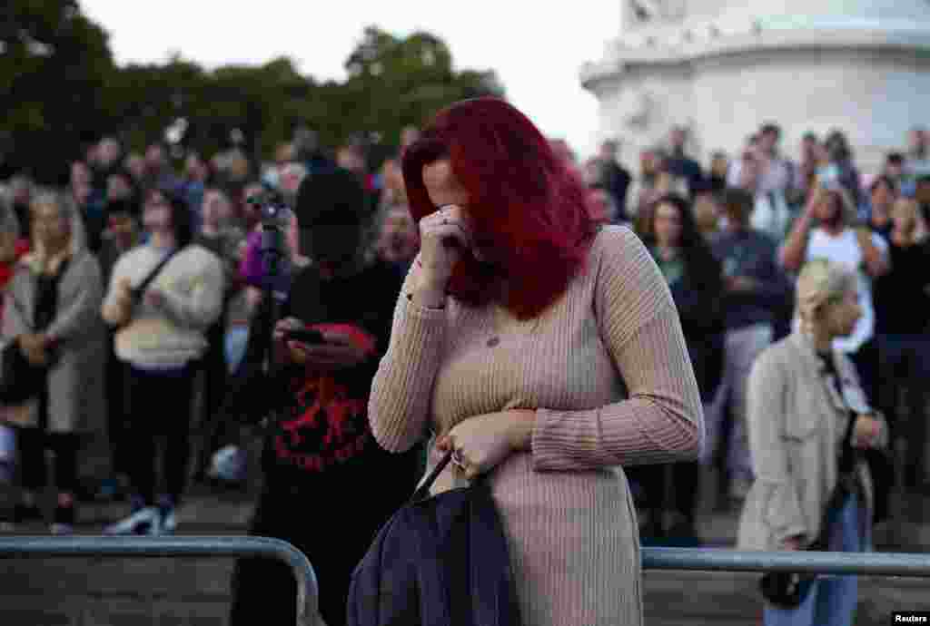 A woman reacts outside Buckingham Palace in London, Sept. 8, 2022.