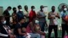 FILE - Migrants who crossed the U.S.-Mexico border illegally and turned themselves in receive assistance at a respite center, in Del Rio, Texas, June 16, 2021.