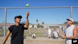 Stefan Schneider, left, shares advice on his serve technique with San Quentin State Prison inmate Kenny Rogers in San Quentin, Calif., Aug. 13, 2022.
