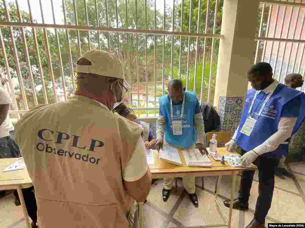 Observadores e funcionários de mesa de voto verificam as listas durante as eleições gerais angolanas de 24 de agosto. Luanda, Angola.&nbsp;