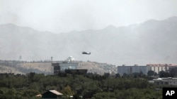 FILE - A U.S.-made Black Hawk military helicopter is seen flying over Kabul, Afghanistan, Aug. 15, 2021.