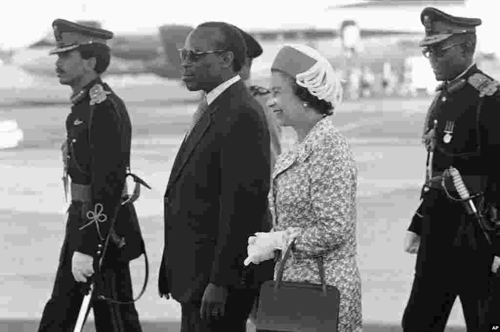 Queen Elizabeth II of England is escorted by Botswana President, Sir Seretse Khama, and his son Brig. Gen Ian Khama on her arrival in Gaberone, Botswana on July 25, 1979, the third stop on the Queen&#39;s four-nation Africa tour. (AP Photo)