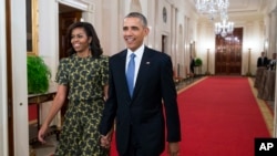 FILE –Former President Barack Obama walks with his wife Michelle Obama in the White House on Nov. 24, 2015. Portraits of the two will be unveiled at the White House on Wednesday.
