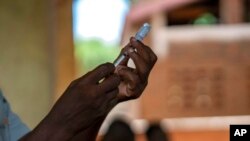 FILE - Health officials prepare to administer a vaccine in the Malawi village of Tomali, Dec. 11, 2019. This week, Nigeria announced provisional approval of the R21 vaccine designed to prevent malaria.