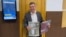 'Novaya Gazeta' lawyer Yaroslav Kozheurov holds copies of 'Novaya Gazeta''s magazine 'No' ('But') at a court building in Moscow, Sept. 6, 2022.
