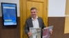 Pengacara Novaya Gazeta Yaroslav Kozheurov memegang salinan majalah Novaya Gazeta di gedung pengadilan di Moskow, Rusia, Selasa 6 September 2022.