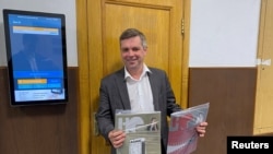 Юрист «Новой газеты» Ярослав Кожеуров держит экземпляры журнала «Новая рассказ-газета» в здании суда, 6 сентября 2022 года