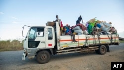 FILE - Displaced families from the community of Impire in the Cabo Delgado province travel on a flatbed truck as they flee on June 14, 2022, from armed insurgents who attacked their community two days earlier. 