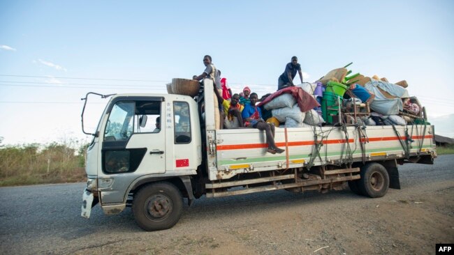 FILE - Displaced families from the community of Impire in the Cabo Delgado province travel on a flatbed truck as they flee on June 14, 2022, from armed insurgents who attacked their community two days earlier.