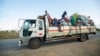 FILE - Displaced families from the community of Impire in the Cabo Delgado province are seen traveling on June 14, 2022, on a flatbed truck as they flee armed insurgents who attacked their community two days earlier. 