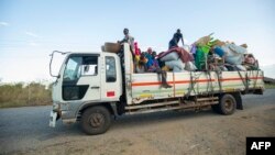 FILE - Displaced families from the community of Impire in the Cabo Delgado province are seen traveling on June 14, 2022, on a flatbed truck as they flee armed insurgents who attacked their community two days earlier. 