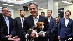 US Secretary of State Antony Blinken, center, holds a landmine sniffer dog, Jack Russell Terrier Patron, during his visits to a children hospital in Kyiv, Ukraine Thursday, Sept. 8, 2022. (Genya Savilov, Pool Photo via AP)