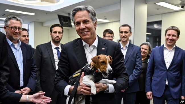 US Secretary of State Antony Blinken, center, holds a landmine sniffer dog, Jack Russell Terrier Patron, during his visits to a children hospital in Kyiv, Ukraine Thursday, Sept. 8, 2022. (Genya Savilov, Pool Photo via AP)