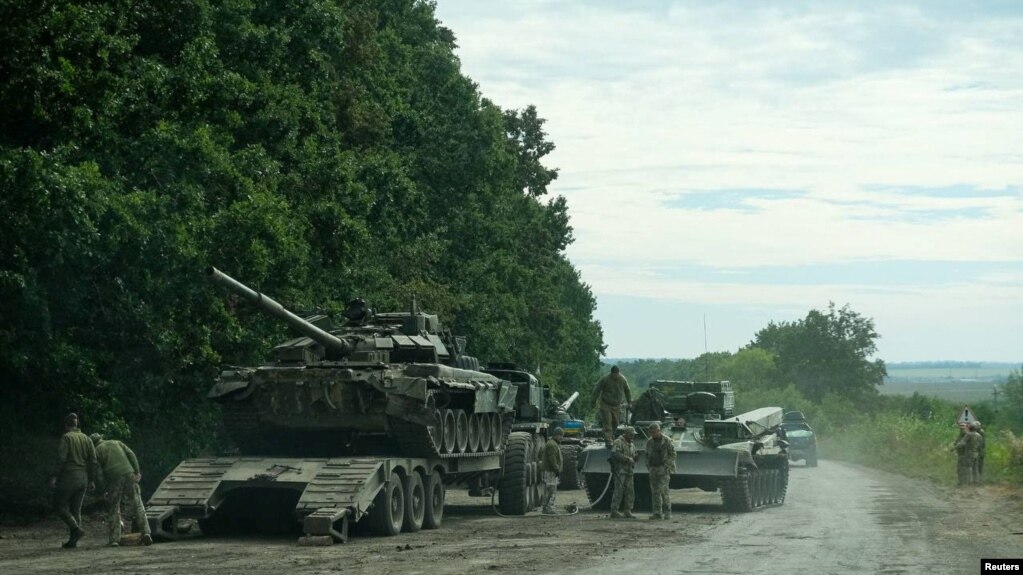Українські військові готуються транспортувати російський танк, захоплений під час контрнаступальної операції у Харківській області восени 2022 року.