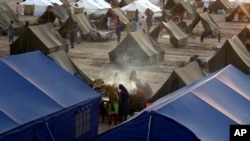 Victims of heavy flooding from monsoon rains take refuge as they prepare tea at a temporary tent housing camp organized by the UN Refugee Agency (UNHCR), in Sukkur, Pakistan, Saturday, Sept. 10, 2022. 