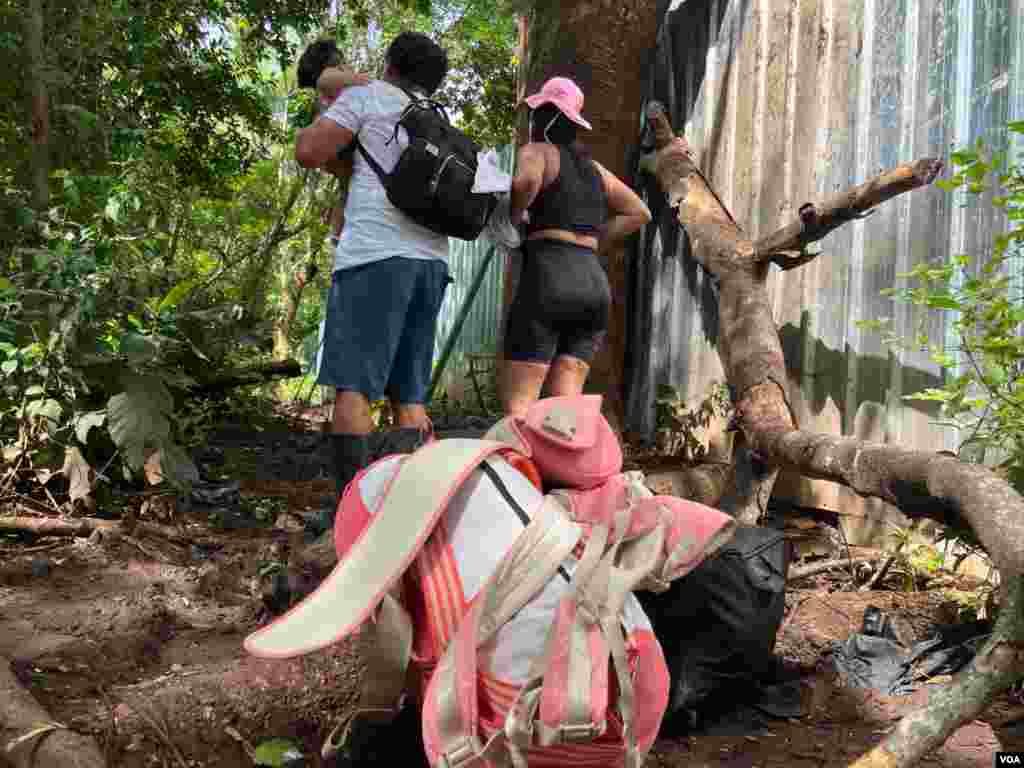 Una familia de migrantes nicaragüenses, luego de cruzar el muro de metal, ya en territorio de Costa Rica. [Oscar Navarrete: La Prensa- VOA]