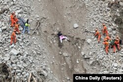 Petugas penyelamat mengevakuasi penduduk yang terkena dampak gempa di lokasi tanah longsor di dekat kota Moxi, menyusul gempa berkekuatan 6,8 di daerah Luding, Prefektur Otonomi Tibet Ganzi, Provinsi Sichuan, China, 6 September 2022. (Foto: China Daily via Reuters)