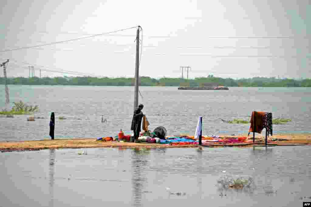 An internally displaced flood-affected man washes his clothes in a flood-hit area following heavy rains in Dera Allah Yar town of Jaffarabad district in Balochistan province, Pakistan.