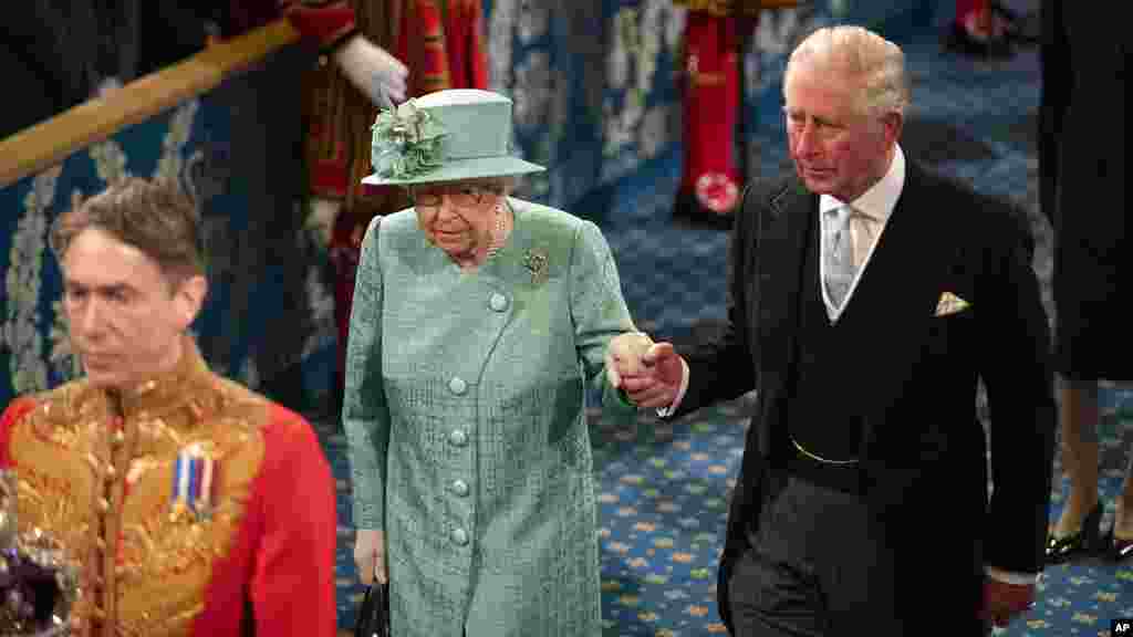 লন্ডনের ওয়েস্টমিনস্টারে সংসদের রাষ্ট্রীয় উদ্বোধনী অনুষ্ঠানে রানী দ্বিতীয় এলিজাবেথ ভাষণ দিতে যাওয়ার সময়ে তার সাথে রাজা তৃতীয় চার্লস, ২০১৯।