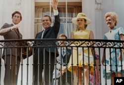 Presiden Richard Nixon melambaikan tangannya dari balkon Executive Mansion saat dia dan ibu negara Pat Nixon (kanan), bersama Pangeran Charles (kiri), dan Putri Anne dari Inggris, 16 Juli 1970. (AP)