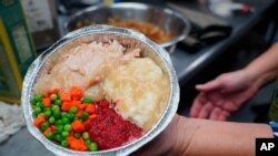 Volunteers prepare individual Thanksgiving meals for seniors in Hawthorne, N.J., on Nov. 3, 2020. With a fall surge of coronavirus infections gripping the US, many Americans are forgoing tradition and getting creative with celebrations.