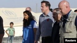 Britain's PMr David Cameron walks with Jordanian Foreign Minister Nasser Judeh and UNHCR representative to Jordan Andrew Harper during his visit to Al-Zaatri refugee camp in the Jordanian city of Mafraq, November 7, 2012. 