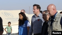 Perdana Menteri Inggris David Cameron (tiga dari kanan) didampingi Menlu Yordania Nasser Judeh (dua dari kanan) wakil dari PBB urusan Pengungsi (UNHCR) Jordan Andrew Harper (kanan) mengunjungi perkemahan pengungsi Al-Zaatri di kota Mafraw, dekat perbatasan Suriah (7/11).