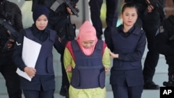 Indonesian Siti Aisyah, center, escorted by police, leaves Shah Alam High Court after a court hearing in Shah Alam, Malaysia on Tuesday, Dec. 18, 2018. 