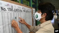 Maryory Vega checks her name on a voting roster during general elections, at a voting center at the Liceo de Moravia school in San Jose, Costa Rica, Feb. 6, 2022. 