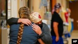 FILE - ICU nurse Melinda Hunt, facing, hugs the sister of a COVID-19 patient she had been caring for, who had just died, inside a COVID unit at Willis-Knighton Medical Center in Shreveport, La., Aug. 18, 2021.