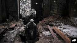 A Ukrainian serviceman moves through the ruins of an industrial compound on a frontline position outside Avdiivka, Donetsk region, eastern Ukraine, Feb. 4, 2022. 